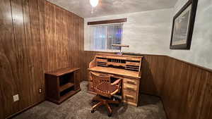 Office space with wood walls and dark carpet