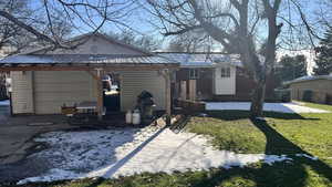 View of side of property with a gazebo, a patio area, a lawn, a metal roof, and an outbuilding