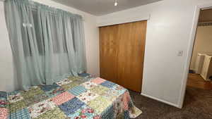 Carpeted bedroom with a closet and baseboards