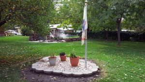 View of green lawn featuring a patio area and an outdoor fire pit