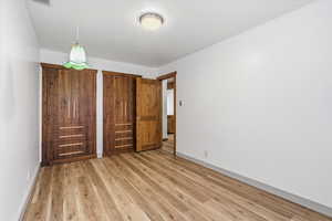 Unfurnished bedroom with light wood-style floors and a closet
