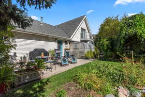 Rear view of house featuring a patio, brick siding, and a shingled roof