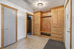 Mudroom featuring wooden walls and a textured ceiling