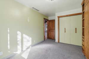 Unfurnished bedroom featuring light carpet and a closet