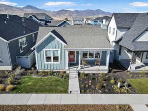 View of front of property featuring board and batten siding, a porch, roof with shingles, and a mountain view