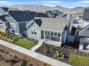 View of front facade with board and batten siding, a shingled roof, a porch, a mountain view, and a residential view