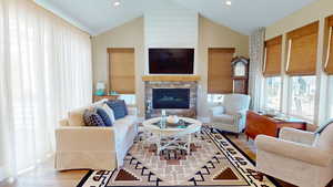 Living room with woven wood finished floors, a linear fireplace, high vaulted ceiling, and recessed lighting