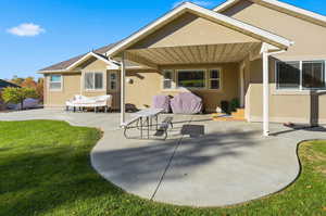 Rear view of house with a patio, stucco siding, a lawn, and a shingled roof