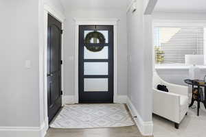 Foyer featuring light wood-type flooring and arched walkways