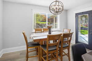 Dining area with healthy amount of natural light, light wood-style flooring, and a chandelier