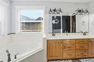 Bathroom featuring double vanity and a whirlpool tub