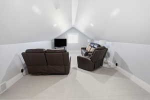Living area featuring light colored carpet and lofted ceiling