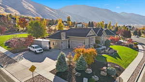 View of front of property featuring a front lawn, driveway, a mountain view, and an attached garage