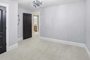 Unfurnished bedroom featuring a chandelier and baseboards