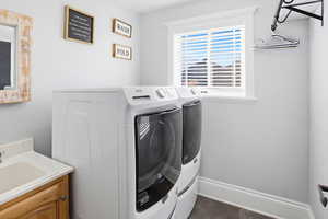 Washroom featuring washing machine and clothes dryer and baseboards