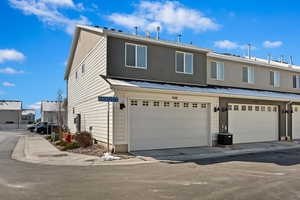 View of front facade with an attached garage and stucco siding