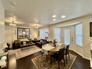 Dining area featuring dark wood-style flooring, a textured ceiling, and recessed lighting