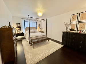 Bedroom featuring dark wood finished floors and baseboards