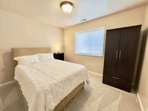 Bedroom featuring light colored carpet and baseboards