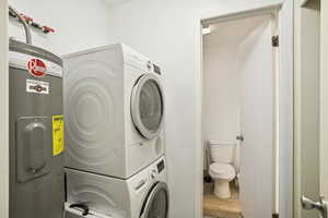 Washroom with electric water heater and stacked washing machine and dryer