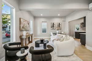 Living area featuring healthy amount of natural light, light wood-style flooring, recessed lighting, and a wall mounted AC