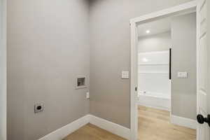 Laundry room featuring light wood finished floors, electric dryer hookup, and hookup for a washing machine