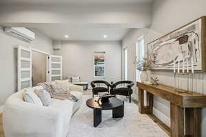 Living room featuring a wall mounted air conditioner, recessed lighting, and wood finished floors