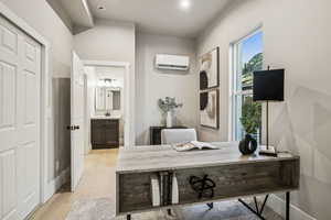 Office featuring light wood finished floors and a wall unit AC