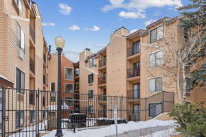 Snow covered building featuring a view of apartment building / complex
