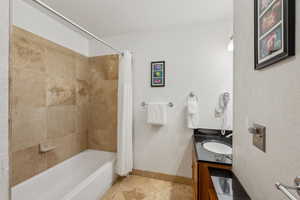 Full bath with shower / bath combo with shower curtain and vanity