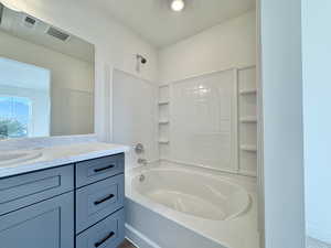 Full bath featuring vanity and washtub / shower combination
