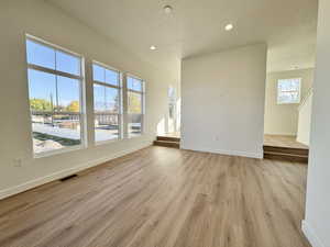 Spare room featuring light wood-type flooring, recessed lighting, and a textured ceiling