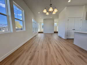 Unfurnished dining area featuring recessed lighting, light wood-style flooring, and a chandelier