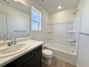 Full bath featuring tub / shower combination, light wood finished floors, and vanity