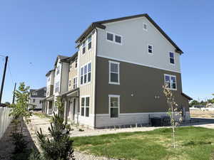 View of side of property with brick siding and a central AC unit