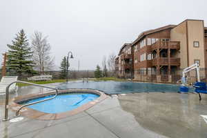 Community pool with a patio and a community hot tub