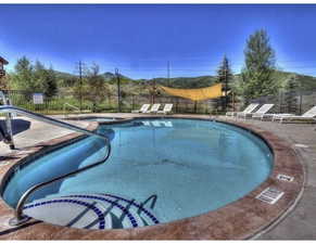 Community pool with a patio, a community hot tub, and a mountain view