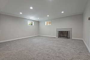 Basement featuring recessed lighting, light carpet, and a fireplace with flush hearth