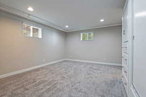 Below grade area with healthy amount of natural light, recessed lighting, and light colored carpet