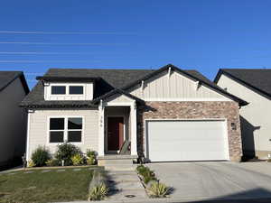 View of front of home featuring board and batten siding, an attached garage, concrete driveway, and roof with shingles