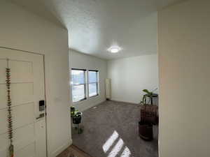 Foyer entrance featuring baseboards and a textured ceiling