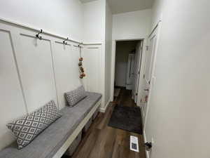 Mudroom featuring dark wood-type flooring and baseboards
