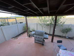 Fenced backyard with a patio area, a grill, and a mountain view