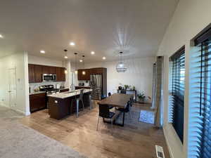 Dining area with light wood-type flooring and recessed lighting