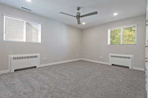 Unfurnished room featuring radiator heating unit, recessed lighting, light carpet, and a ceiling fan