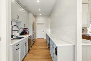 Prep-Kitchen with tasteful backsplash, light stone countertops, recessed lighting, light wood-type flooring, and stainless steel dishwasher