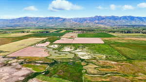 Overview of rural landscape featuring abundant farmland and a water and mountain view