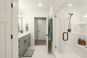 Full bathroom with vanity, a shower stall, light tile patterned flooring, and recessed lighting