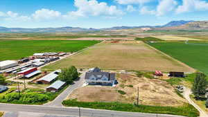 Aerial view of Main home, barnyard, crops and a mountainous background
