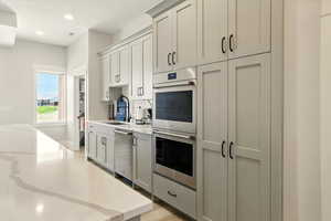 Prep-Kitchen featuring appliances with stainless steel finishes, light stone counters, recessed lighting, light wood-style floors, and gray cabinetry
